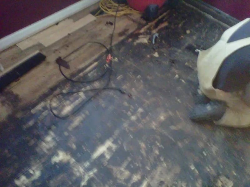 Damaged hardwood floor before restoration in a Beeline Floors project